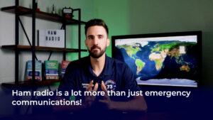 Presenter in a studio with a world map display and bookshelf; on‑screen text reads “Ham radio is a lot more than just emergency communications!”