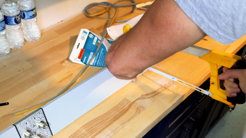 Marking and cutting the HDPE wing to length with a hacksaw.