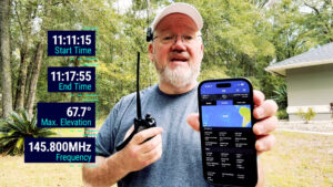 “Ham operator holding a handheld radio and phone with ISS Detector app, showing high-elevation ISS pass times and 145.800 MHz for SSTV reception.”