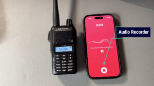 Yaesu FT-65 tuned to 145.800 MHz next to a smartphone voice-recorder app capturing ISS slow-scan TV audio for later decoding.