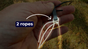 Close-up of two support ropes tied to an antenna insulator during a wire antenna installation.
