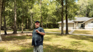 Professor Jim standing in the yard while raising wire into the trees for the first antenna at the new QTH.