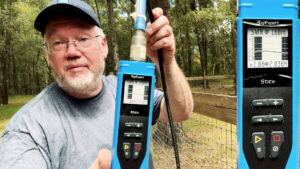 Professor Jim holding an antenna analyzer showing SWR on 160 meters during testing of the new wire antenna.